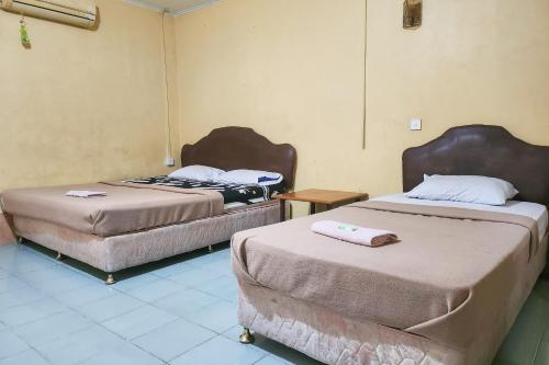 a room with two beds in a room at Hotel Tanjung Pinang Jaya RedPartner in Tanjung Pinang 
