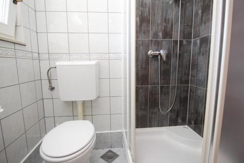 a bathroom with a toilet and a shower at Villas Corinthia in Baška