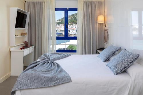 um quarto com uma cama grande e uma janela em Hotel Spa Cap de Creus em Port de la Selva