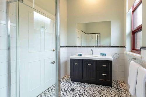 a bathroom with a shower and a sink and a mirror at Club Wyndham Ballarat, Trademark Collection by Wyndham in Ballarat