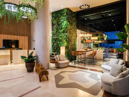 a lobby with a green wall with a table and chairs at Grand Mercure SP Itaim Bibi in São Paulo