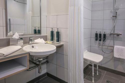ストラトフォード・アポン・エイボンにあるDoubleTree by Hilton Stratford-upon-Avon, United Kingdomの白いバスルーム(シンク、シャワー付)