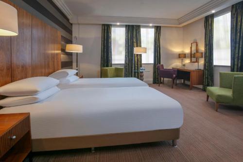 um quarto de hotel com uma cama grande e uma secretária em DoubleTree by Hilton Stratford-upon-Avon, United Kingdom em Stratford-upon-Avon