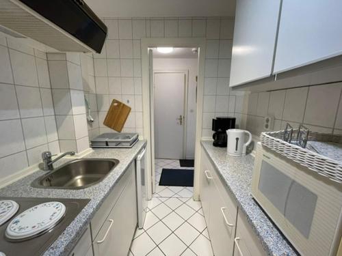 uma cozinha com um lavatório e uma bancada em Appartement Sylter Residenz 16 57 em Westerland