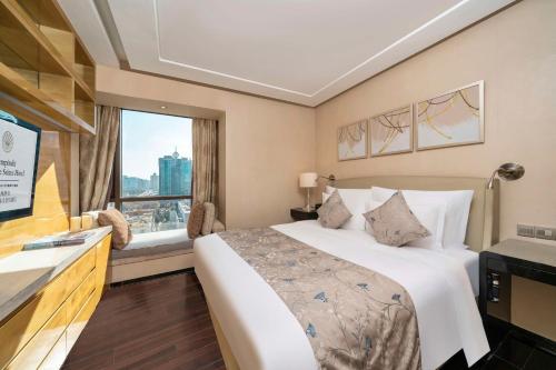 a hotel room with a bed and a window at Kempinski The One Suites Hotel Shanghai Downtown in Shanghai