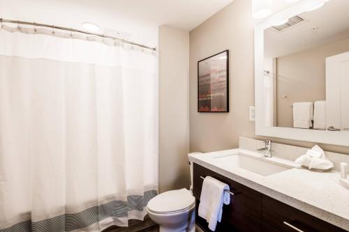 W łazience znajduje się umywalka, toaleta i lustro. w obiekcie TownePlace Suites by Marriott Cleveland w mieście Cleveland
