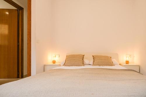 a bedroom with a large bed with two night stands at Ca lEudald 1 Descubre Besalú en familia in Besalú