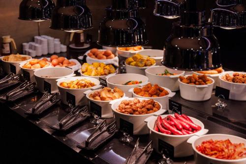 a buffet with many bowls of food on a table at Palace Hotel Tallinn, a member of Radisson Individuals in Tallinn