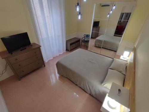 een slaapkamer met een bed en een televisie en een spiegel bij Casetta Fardella 95 in Trapani