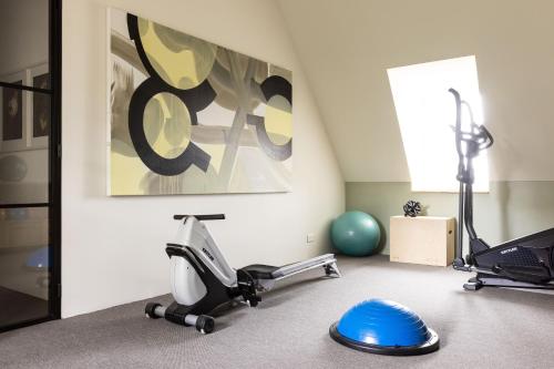 a room with a gym with exercise equipment in it at Chateau De La Resle - Design Hotels in Montigny-la-Resle