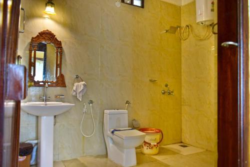 a bathroom with a white toilet and a sink at Hillfort Hotels & Resorts Yelagiri in Yelagiri