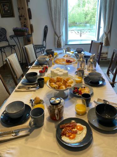 - une table remplie de nourriture pour le petit-déjeuner dans l'établissement Le Moulin de Visargent, à Sens sur Seille