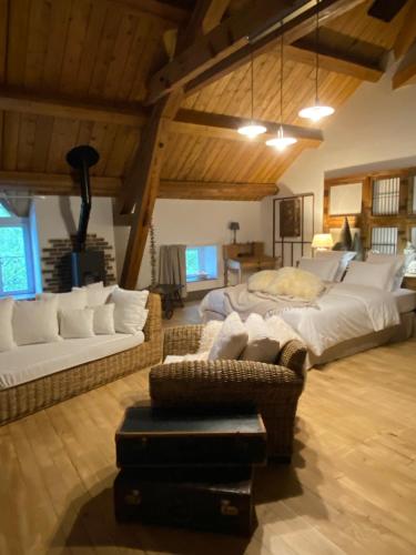 a large living room with two beds and a couch at Le Moulin de Visargent in Sens sur Seille