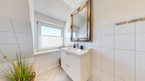 un baño con lavabo y espejo en Inselloft, en Hörnum