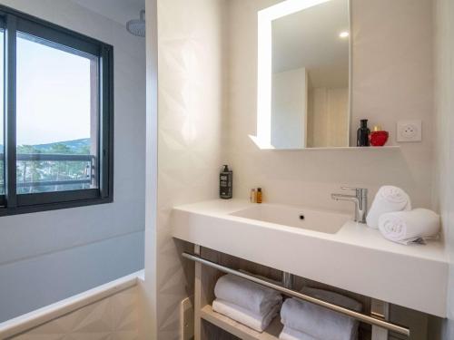 bagno con lavandino e specchio di ibis Styles Porto Vecchio a Porto Vecchio