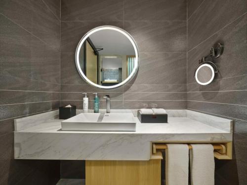 bagno con lavandino e specchio di Hilton Garden Inn Aksu Downtown ad Aksu