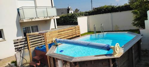 a swimming pool with a hose in a backyard at résidence des dunes in Landéda