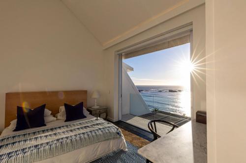 a bedroom with a bed and a large window at Clifton Ezulwini in Cape Town