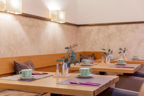 comedor con mesas y sillas de madera en AlpenParks Hotel Maria Alm, en Maria Alm am Steinernen Meer