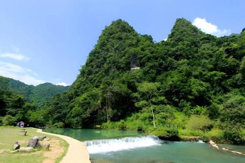 a river with a mountain in the background at Mai Anh Homestay - Pac Bo Village in Choc Mu