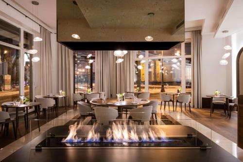 a restaurant with a fireplace in the middle of the room at Grand Hotel Vilnius, Curio Collection by Hilton in Vilnius