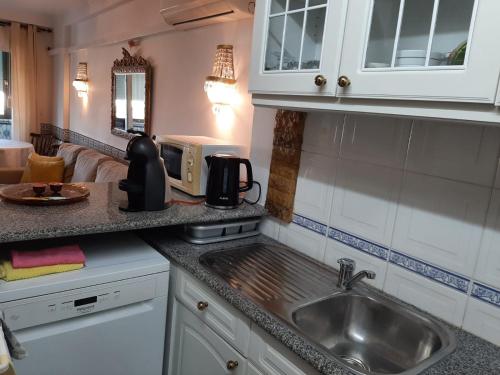cocina con fregadero y microondas en Ocean House, en Costa da Caparica