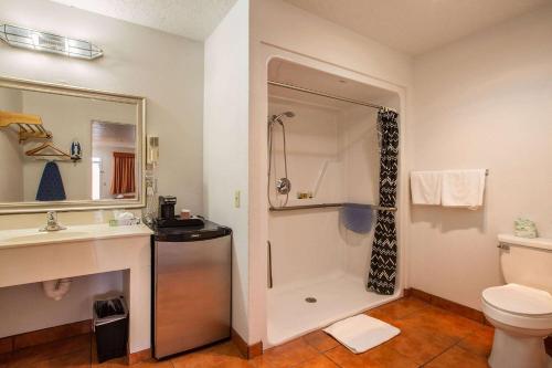 a bathroom with a shower and a toilet and a sink at Sandia Peak Inn, a Howard Johnson by Wyndham in Albuquerque
