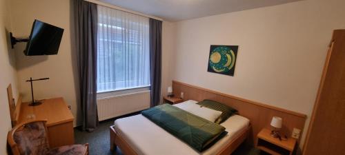 ein Hotelzimmer mit einem Bett und einem Fenster in der Unterkunft Hotel Alt Oesselse in Hannover