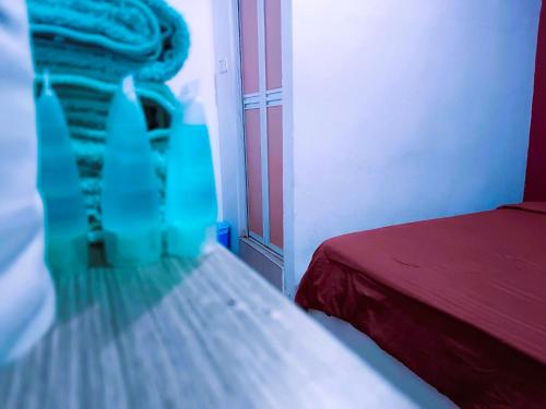 a bedroom with a bed and a red bedspread at BMW Hotel in Muar