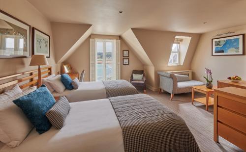 a hotel room with two beds and a chair at Braye Beach Hotel in Braye