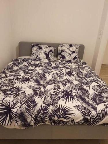 - un lit avec une couverture et des oreillers noirs et blancs dans l'établissement Logement Super Cosy Rue Mourre, à Avignon