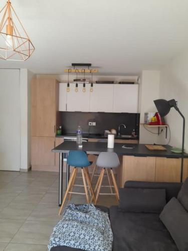 une cuisine avec une table et des chaises dans une pièce dans l'établissement Logement Super Cosy Rue Mourre, à Avignon