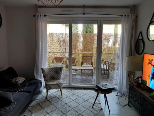un salon avec un canapé et une porte coulissante en verre dans l'établissement Logement Super Cosy Rue Mourre, à Avignon
