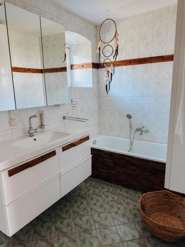 a bathroom with a sink and a bath tub at Weingut Holler Chalet Weingarten in Spielfeld
