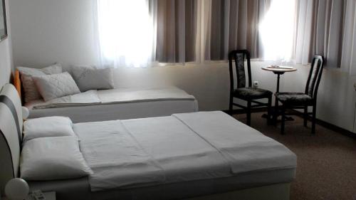 una camera d'albergo con letto, tavolo e sedie di Holiday In Bihać a Bihać