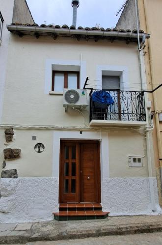 a white house with a door and a balcony at La Encina del Abuelo in La Adrada