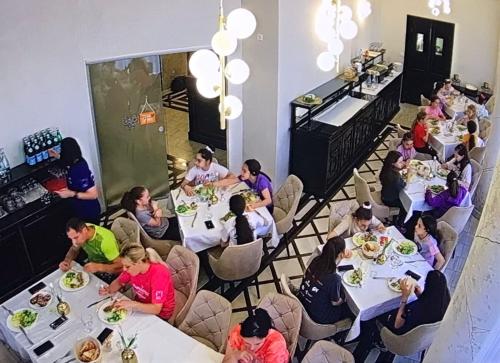 een groep mensen die aan tafel zitten in een restaurant bij Hotel Novera in Timişoara