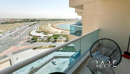 einen Balkon mit einem Stuhl und Strandblick in der Unterkunft Rare Holiday Homes - Studio in Crescent Tower near City Center Mall - R712 IMPZ in Dubai