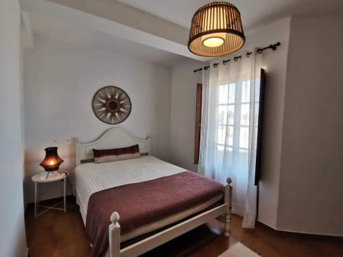 a bedroom with a bed and a clock on the wall at Casa Pereira in Vila Nova de Milfontes