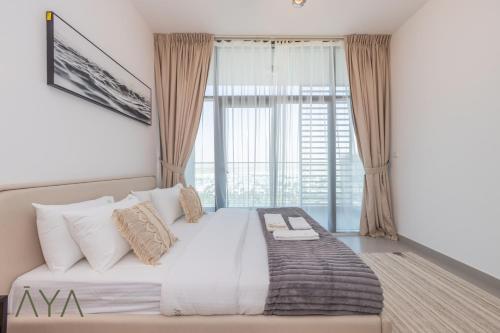 a bedroom with a bed and a large window at Stylish 2BR Apartment at Dubai Hills with Pool Access By ĀYA Boutique in Dubai