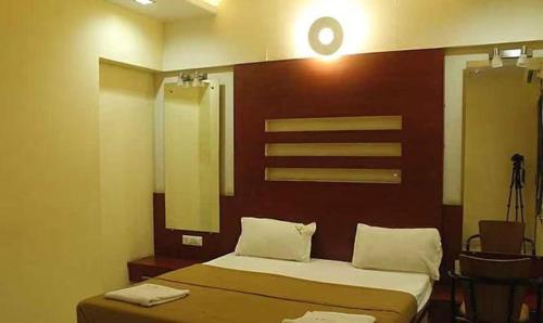 um quarto com uma cama e uma cabeceira em madeira em FabHotel Skylark Inn em Nashik
