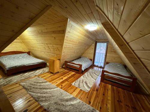 an attic room with two beds and a window at Vikendica sa bazenom MAGNUM in Višegrad