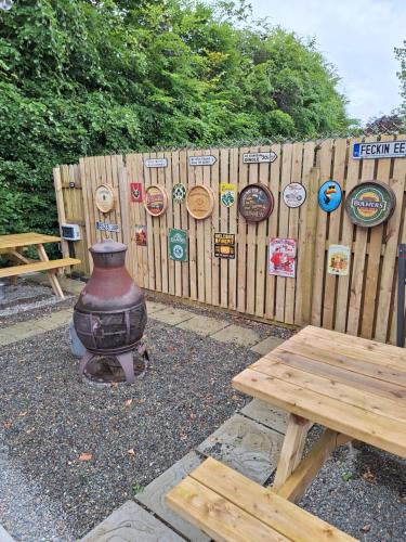 a wooden fence with a vase and a wooden picnic table at Priory Glamping Pods and Guest accommodation in Killarney