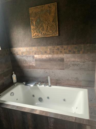 un bagno con vasca e foto appese alla parete di Boutique bungalow a Haverhill