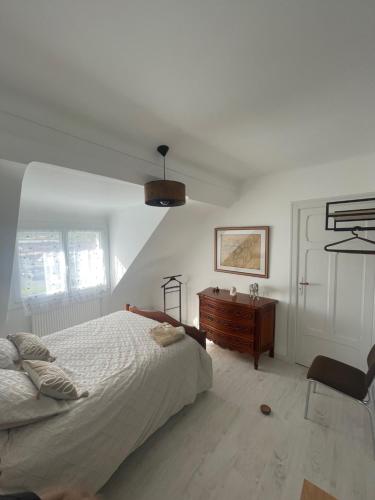 une chambre avec un lit et une commode en bois dans l'établissement Appartement Mansoreau, au Mans