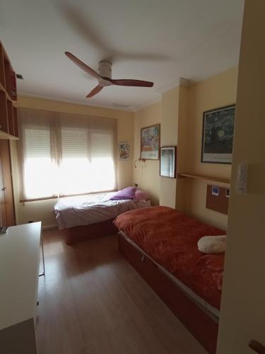 ein Schlafzimmer mit zwei Betten und einem Deckenventilator in der Unterkunft Casa El Angel Loft Denia centro con parking in Denia