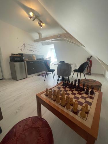 - un échiquier sur une table dans une pièce avec des chaises dans l'établissement Appartement Mansoreau, au Mans