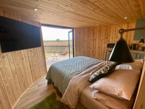 a bedroom with a large bed with a large window at Silo Green in Great Dunmow