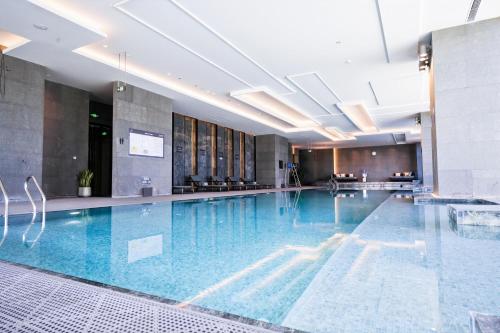 a large swimming pool with blue water in a building at JW Marriott Hotel Taiyuan in Taiyuan