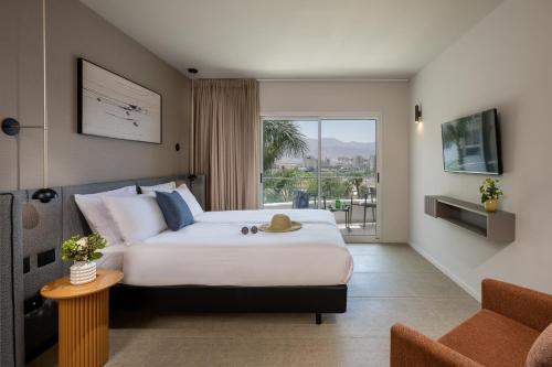 um quarto de hotel com uma cama e uma varanda em Astral Nirvana Suites- Half Board em Eilat